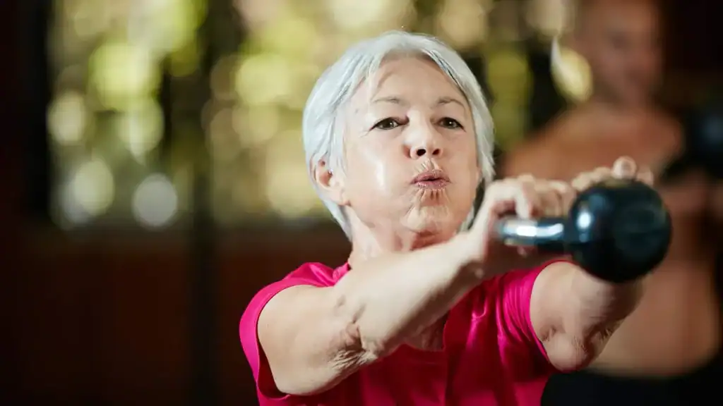 Older woman doing weight training Stratford-upon-Avon to help her strength and longevity 