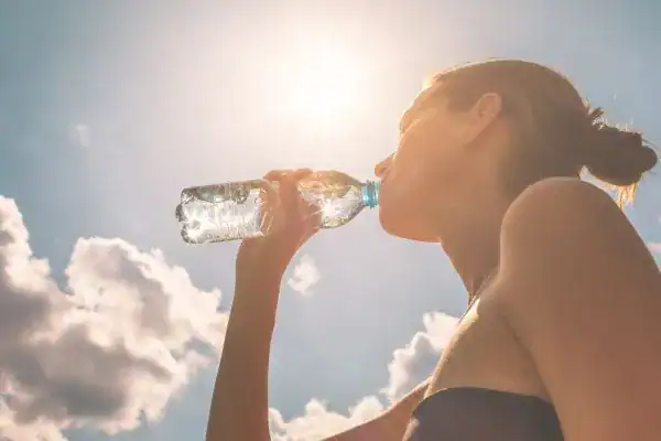 Hydration: The Secret Ingredient for a Toned Stomach and Enhanced Fitness 3 Image of woman drinking water to hydrate Stratford-upon-Avon after run.