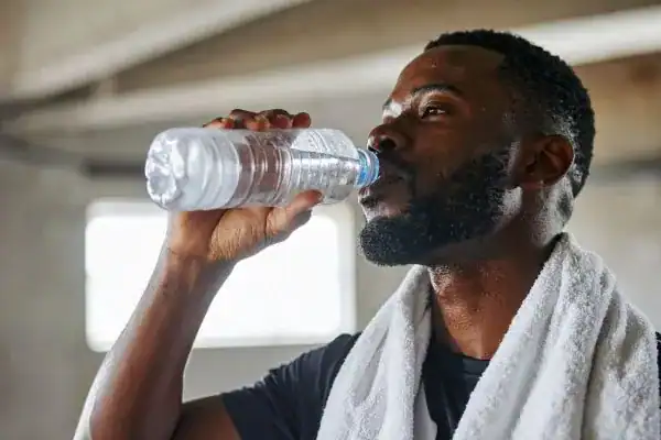 Hydration: The Secret Ingredient for a Toned Stomach and Enhanced Fitness 1 Image of man drinking water to improve hydration Stratford-upon-Avon after work out.